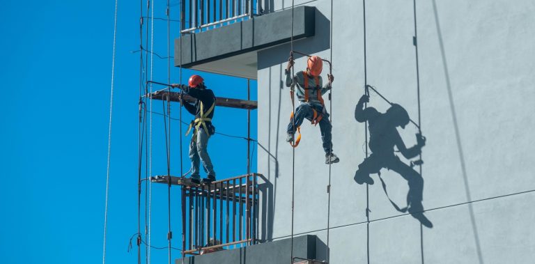 Deux cordistes en intervention sur la façade d'un immeuble